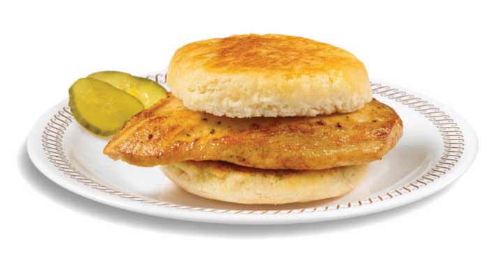 Waffle House Chicken Biscuit with grilled seasoned chicken breast on warm buttermilk biscuit served on white plate with optional cheese